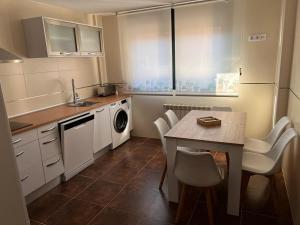 a small kitchen with a table and a sink at La Casita del Risco in Las Navas del Marqués