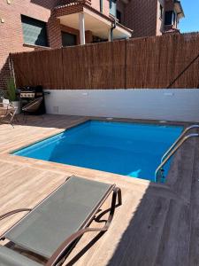 una piscina en un patio trasero con una valla de madera en La Casita del Risco en Las Navas del Marqués