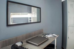 a mirror on a wall above a desk with a laptop at Quart Youth Hostel & Apartments in Valencia