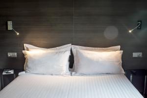 a bed with white sheets and pillows in a room at Quart Youth Hostel & Apartments in Valencia