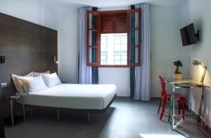 a bedroom with a bed and a window and a table at Quart Youth Hostel & Apartments in Valencia