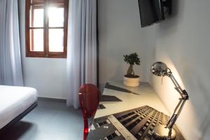 a bedroom with a desk with a lamp and a bed at Quart Youth Hostel & Apartments in Valencia