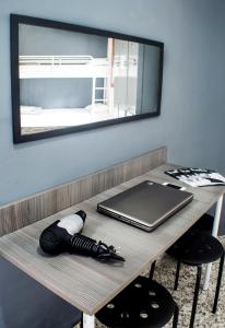 a wooden table with a laptop and a mirror at Quart Youth Hostel & Apartments in Valencia