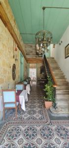 a room with stairs and tables and a chandelier at Hotel Valide Hanim Konak in Lefkosa Turk