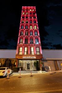 um edifício alto com uma torre vermelha em frente a um edifício em THE HUBİ HOTEL em Istambul