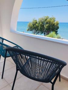 a bench sitting in front of a window with the ocean at Mini Villas Avra in Keratokampos