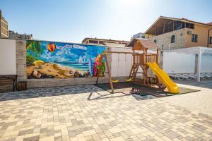 a mural on the side of a building with a playground at OneTime Hotel in Anapa