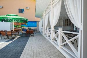 a patio with tables and chairs and an umbrella at OneTime Hotel in Anapa