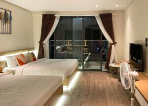 a hotel room with two beds and a balcony at Light House Apec Phu Yen in Liên Trì (3)