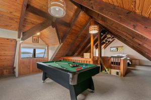 a pool table in a room with wooden ceilings at Splendour on Spencer - Lake Tarawera Holiday Home in Lake Tarawera
