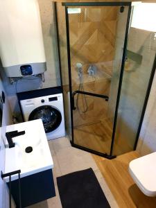 a shower in a bathroom with a washing machine at Osada Gorce in Nowy Targ