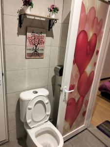 a bathroom with a toilet with a door with a flower design at Homestay Melaka at Mahkota Hotel - unit 3093 - FREE Wifi & Parking in Malacca
