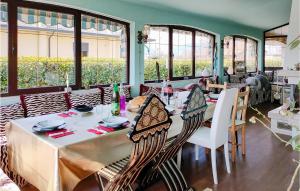 a dining room with a table and chairs and windows at Pet Friendly Home In Loria With Kitchenette in Loria