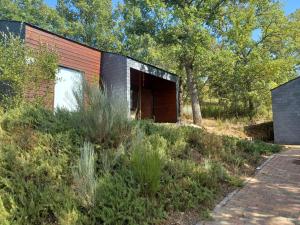 une maison sur une colline avec des arbres et un chemin en briques dans l'établissement Sobre Aguas Camping, à Bragance