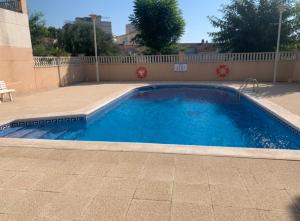 una gran piscina azul junto a un edificio en Casa de playa, en Tarragona