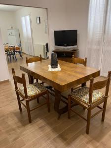 un soggiorno con tavolo e sedie in legno di casaaugello a Menfi