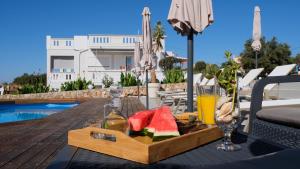 un plateau de fruits sur une table à côté d'une piscine dans l'établissement Villa Sophie, à La Canée