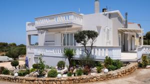 une maison blanche avec un jardin en face dans l'établissement Villa Sophie, à La Canée