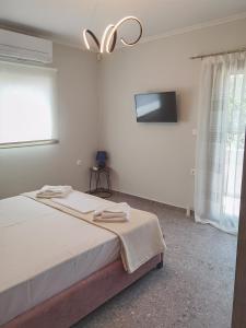 a bedroom with a bed and a flat screen tv at Red in Vlikhón