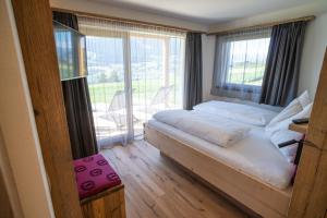 a bedroom with a bed and a large window at Chalet am Wiesenweg in Chiusa