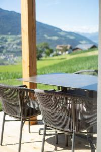 a table and chairs on a patio with a view at Chalet am Wiesenweg in Chiusa