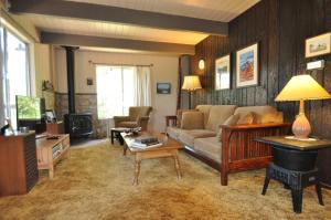 - un salon avec un canapé et un piano dans l'établissement Bigfoot Cabin at Pine Mountain Lake, à Groveland
