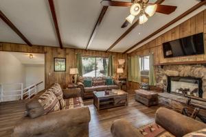 sala de estar con sofá y chimenea en Pet Friendly Grizzly Blair Lodge Cabin, en Groveland