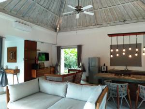 a living room with a couch and a ceiling fan at Balian Bliss Retreat complex with private pool in Balian