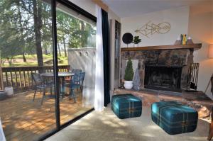 a screened porch with a table and a fireplace at Gnome and Creek Yosemite Condo in Groveland