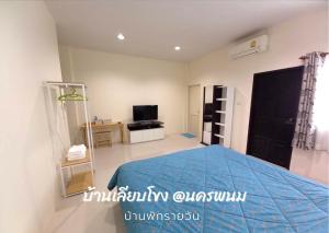 1 dormitorio con 1 cama azul y TV en บ้านเลียบโขง@นครพนม en Ban Nong Puk