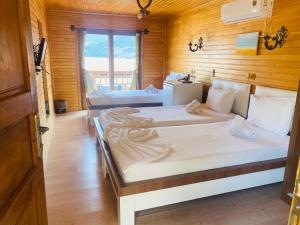 two beds in a room with wooden walls at 7 Green Adrasan in Adrasan