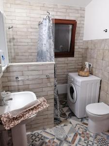 TV y baño con lavabo y aseo. en Agriturismo "PIRASTRERI" en Siniscola