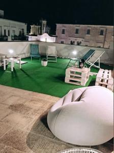 a room with a green floor with chairs on a roof at B&B VOLARE in Polignano a Mare