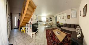 a living room with a couch and a tv and a table at Elsasslogie im Winzerdorf in Cleebourg
