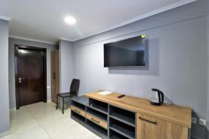 a room with a desk and a tv on the wall at Hotel Rose in Tbilisi City