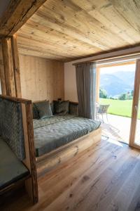 a bed in a room with a large window at Chalet am Wiesenweg in Chiusa