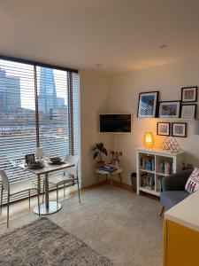 a living room with a table and a view of a city at The Maltings Tower Bridge Apartment in London