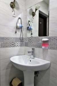 a bathroom with a white sink and a mirror at Hotel Rose in Tbilisi City