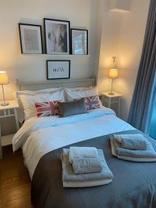 a bedroom with a large bed with towels on it at The Maltings Tower Bridge Apartment in London