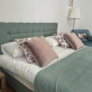 una cama verde con almohadas encima en Zatyshok, en Vínnytsia