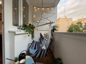 a hammock on a balcony with a window at Modern Retro Apart ~ 800m Main Square in Wrocław