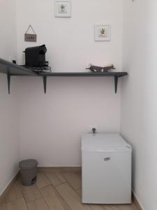 ein Regal an einer Wand mit einem Kühlschrank in einem Zimmer in der Unterkunft Emir Rooms in Posada