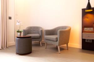 2 sillas y una mesa en una habitación en Woohoo Rooms Boutique Sol, en Madrid