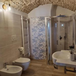 uma casa de banho com um WC, um lavatório e um chuveiro em La tana degli Incerti em Alberobello