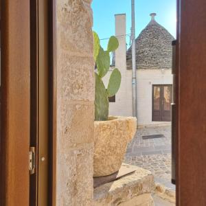 uma planta sentada num vaso do lado de fora de uma porta em La tana degli Incerti em Alberobello