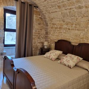 1 dormitorio con 1 cama en una pared de ladrillo en La tana degli Incerti, en Alberobello