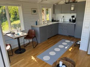 una cocina con armarios grises y una mesa y un Sidx Sidx Sidx Sidx Sidx. en Exclusive guesthouse with stunning Seaview!, en Värmdö