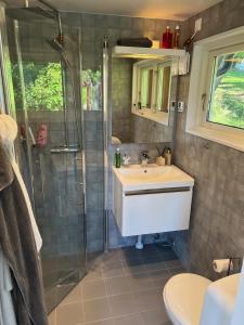 y baño con lavabo y ducha. en Exclusive guesthouse with stunning Seaview! en Värmdö