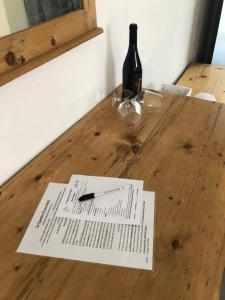a piece of paper on a wooden table with a bottle of wine at Le Quattro Porte in Marsala