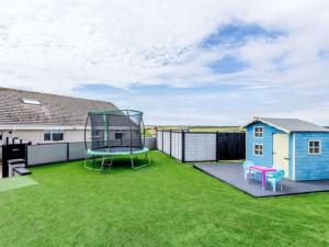 a large backyard with a trampoline and a house at Tigh Na Mhor , Hot Tub , Games Room , 5 Bedroom ,Sleeps 13 , Large Villa in Cruden Bay
